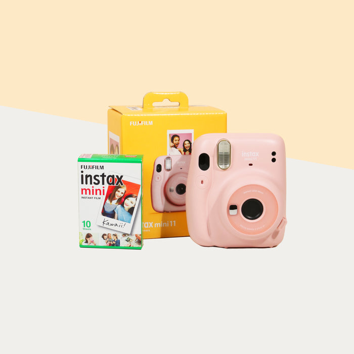 Instax Mini 11 Camera (Blush pink) with the retail box, beside a box of film