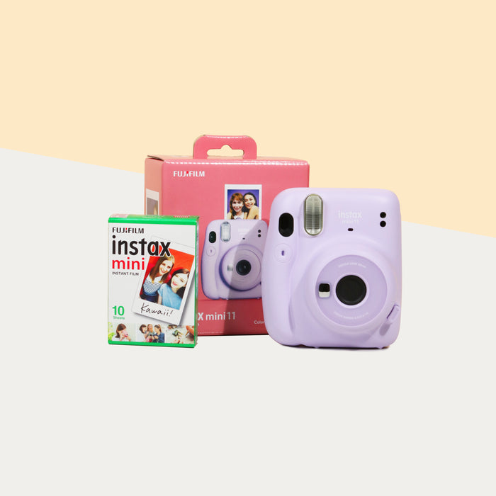 Instax Mini 11 Camera (Lilac purple) with the retail box, beside a box of film