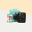 Instax Mini 11 Camera (Charcoal grey) with the retail box, beside a box of film