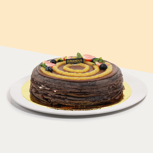 Chocolate mille crepe dusted with cocoa powder, slathered with chocolate pastry cream and blended bananas