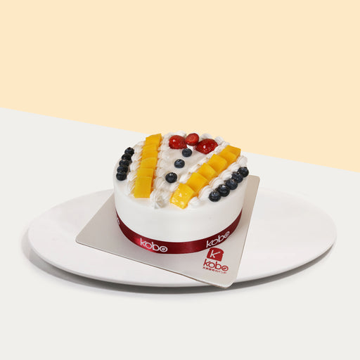 Vanilla sponge cake, decorated with fresh fruits to resemble a tuxedo