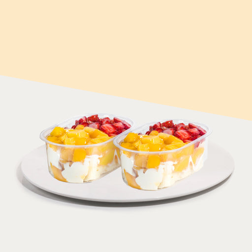 Cakes in a box, with fresh cream, topped with mangoes and strawberries