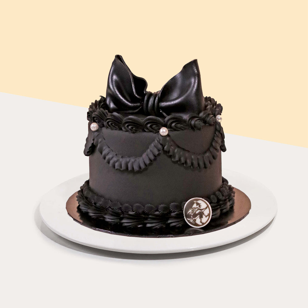 Black chocolate sponge cake, with chocolate cream, black buttercream piping, topped with black fondant ribbon