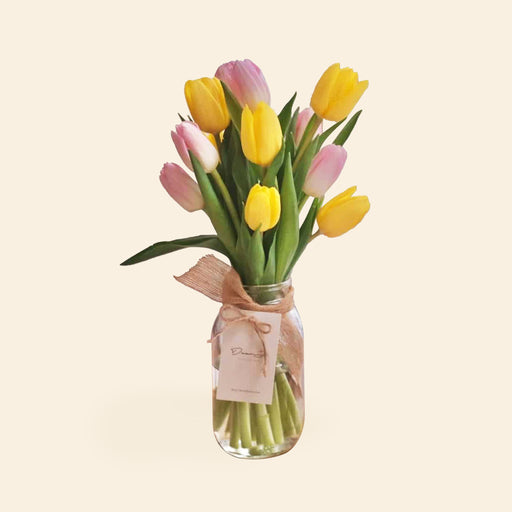 Pink and yellow tulips in a jar