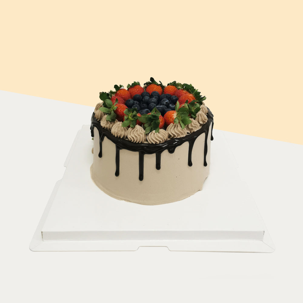Chocolate sponge cake, topped with chocolate glaze, and a bed of fresh fruits
