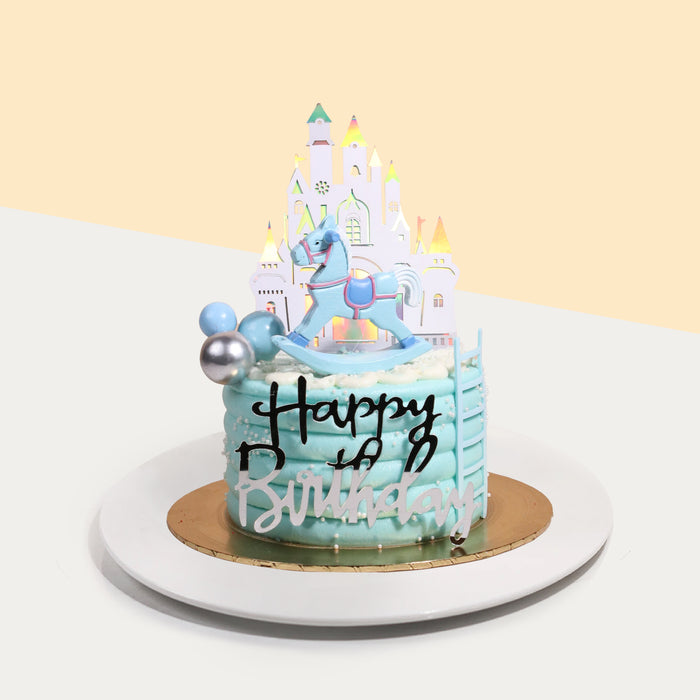 Blue rocking horse themed cake with a 2d printed castle background