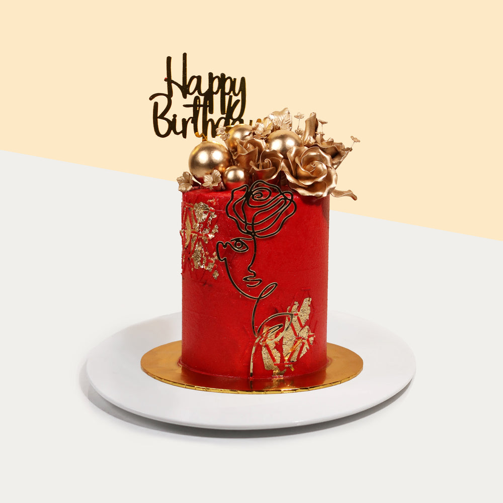Red buttercream frosted butter cake, decorated with gold elements