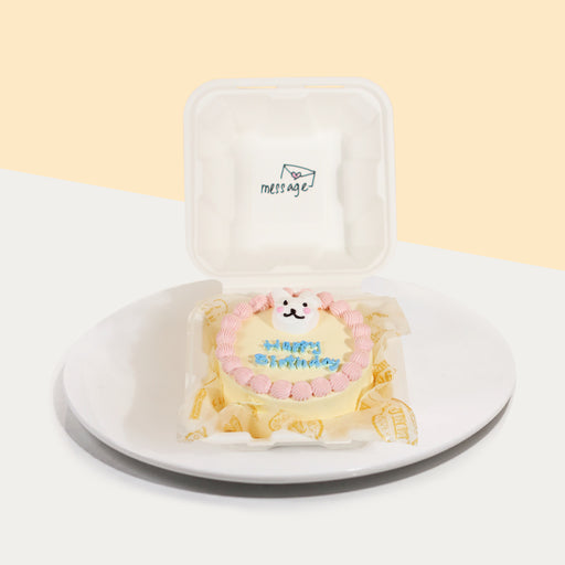 Bento cake with pink cream swirls, and rabbit figurine