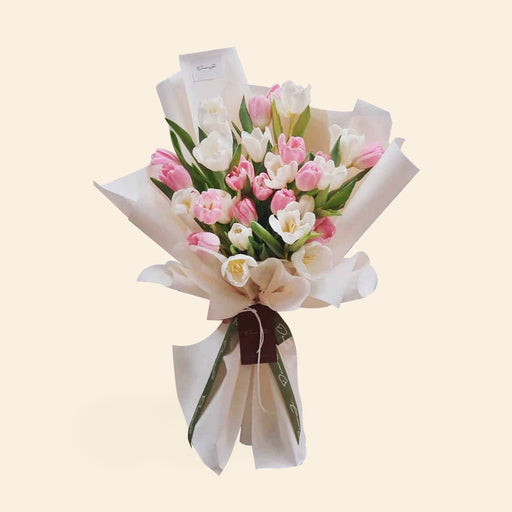 Pink and white tulip flower bouquet, wrapped in white paper
