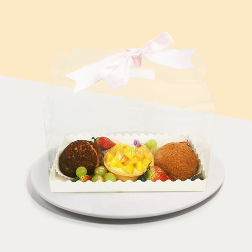 Treat box with a mango tart, Vanilla Profiterole, Chocolate Profiterole and Assorted Fruits 
