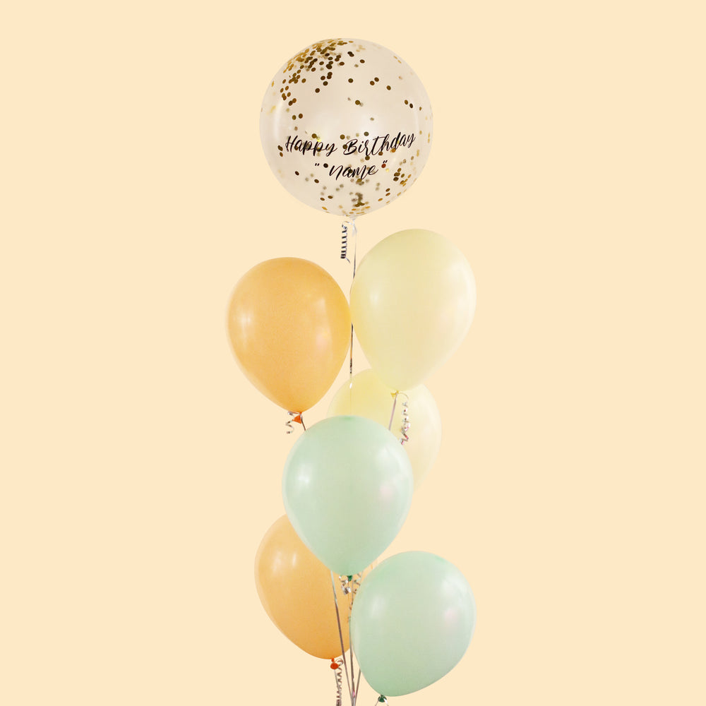 Bundle of balloons with a Happy Birthday, pastel orange, pastel yellow and pastel green balloons