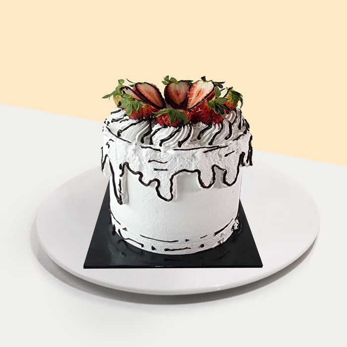 Black and white 2d cake, topped with strawberries