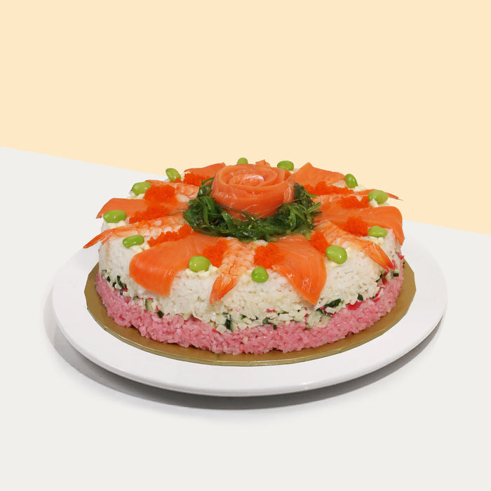 Round sushi cake with raw salmon, cooked prawns and wakame