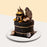 Black designer cake with gold accents, with a money bag decoration