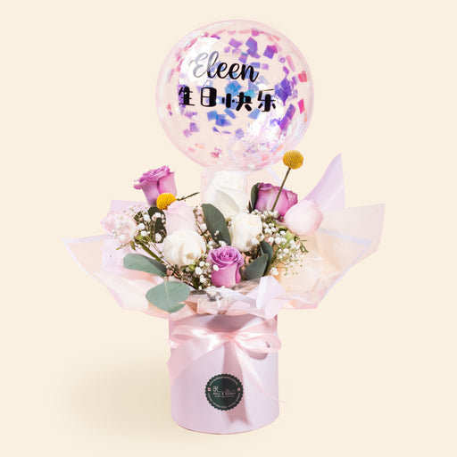 Box of flowers laced with confetti paper, with flower arrangement and confetti balloon