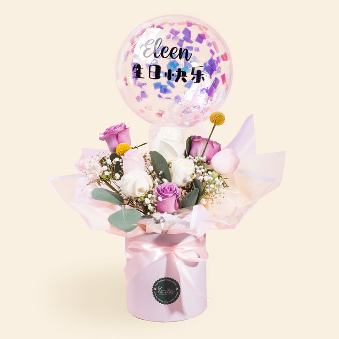 Box of flowers laced with confetti paper, with flower arrangement and confetti balloon