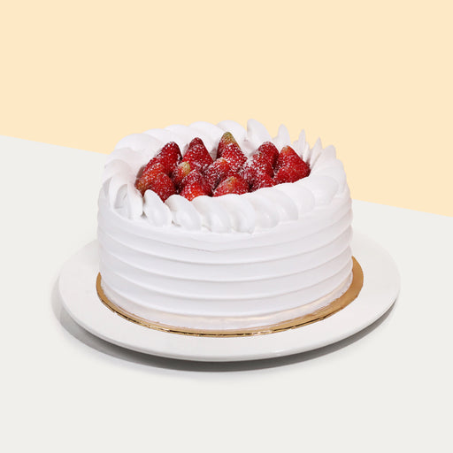 Cake coated with cream, topped with fresh strawberries
