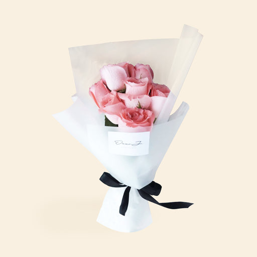 Bouquet of seven roses, wrapped in white paper and black ribbon