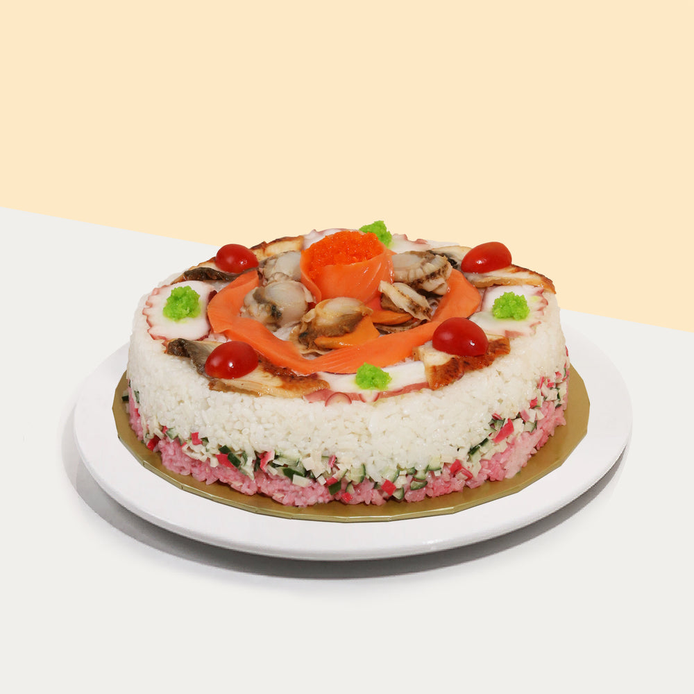 Round sushi cake with unagi, raw salmon, scallops, and a salmon rose filled with ebiko