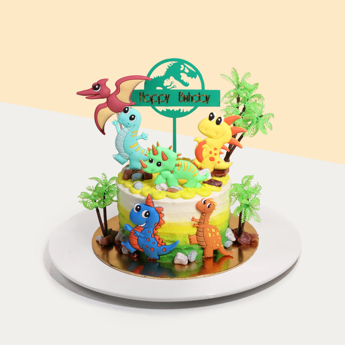 Cake decorated with assorted dinosaur figurines, and plastic trees