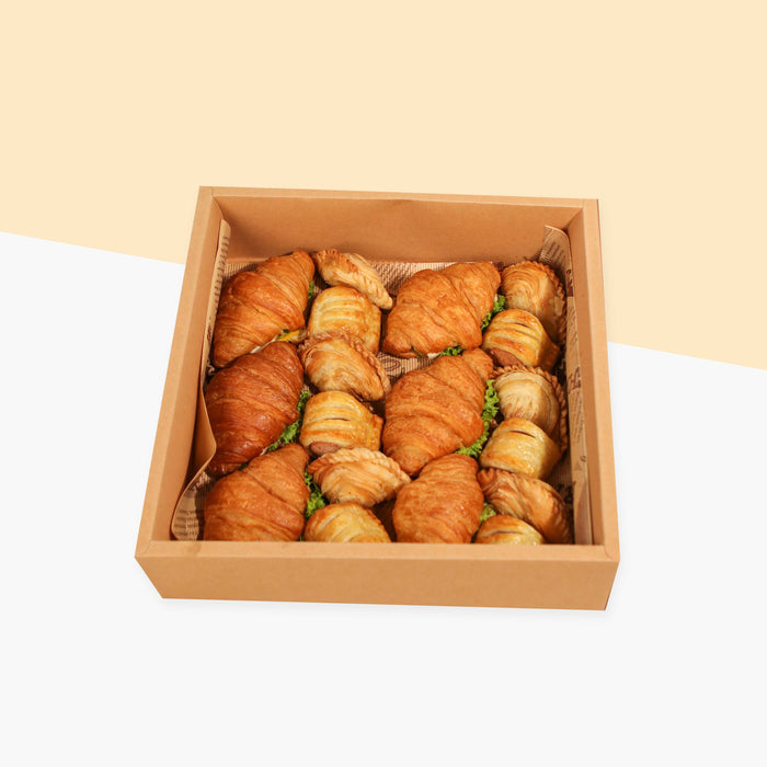 Box of croissants, mini sausage rolls and samosas