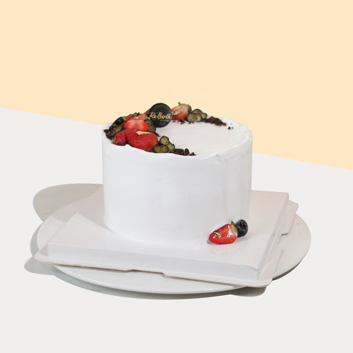 Chocolate sponge cake with dark cherry fillings, topped with fresh strawberries and blueberries