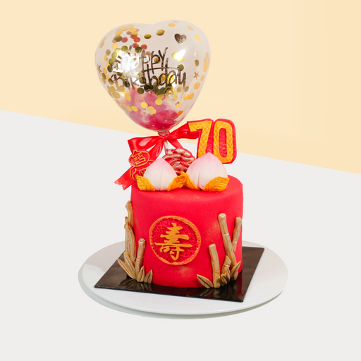 Red longevity cake with chinese peaches, topped with a confetti balloon
