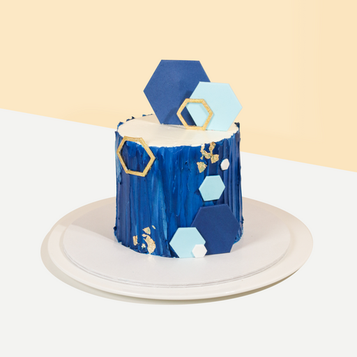Cake frosted in blue, with hexagonal fondant decorations