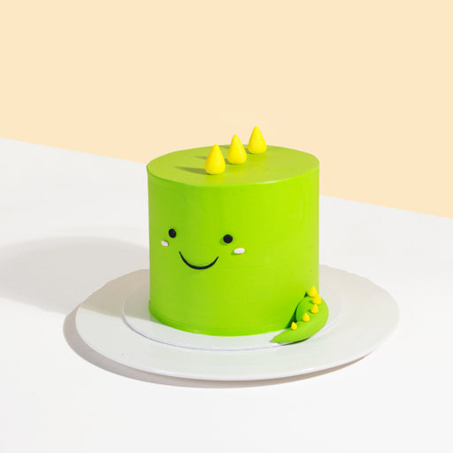 Green buttercream little dinosaur cake, with a smiley face on the side
