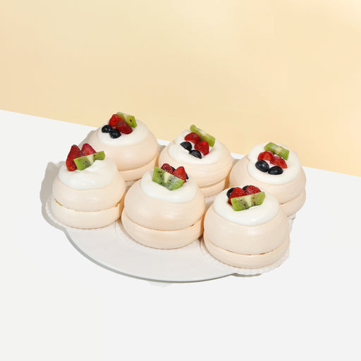 Mini vanilla pavlovas topped with fresh cream and fruits