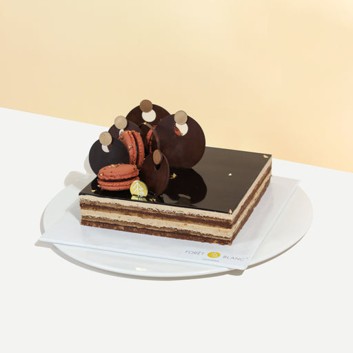 Opera cake with chocolate crunch, espresso infused almond cake, French coffee buttercream, dark chocolate ganache, with a mirror glaze on top