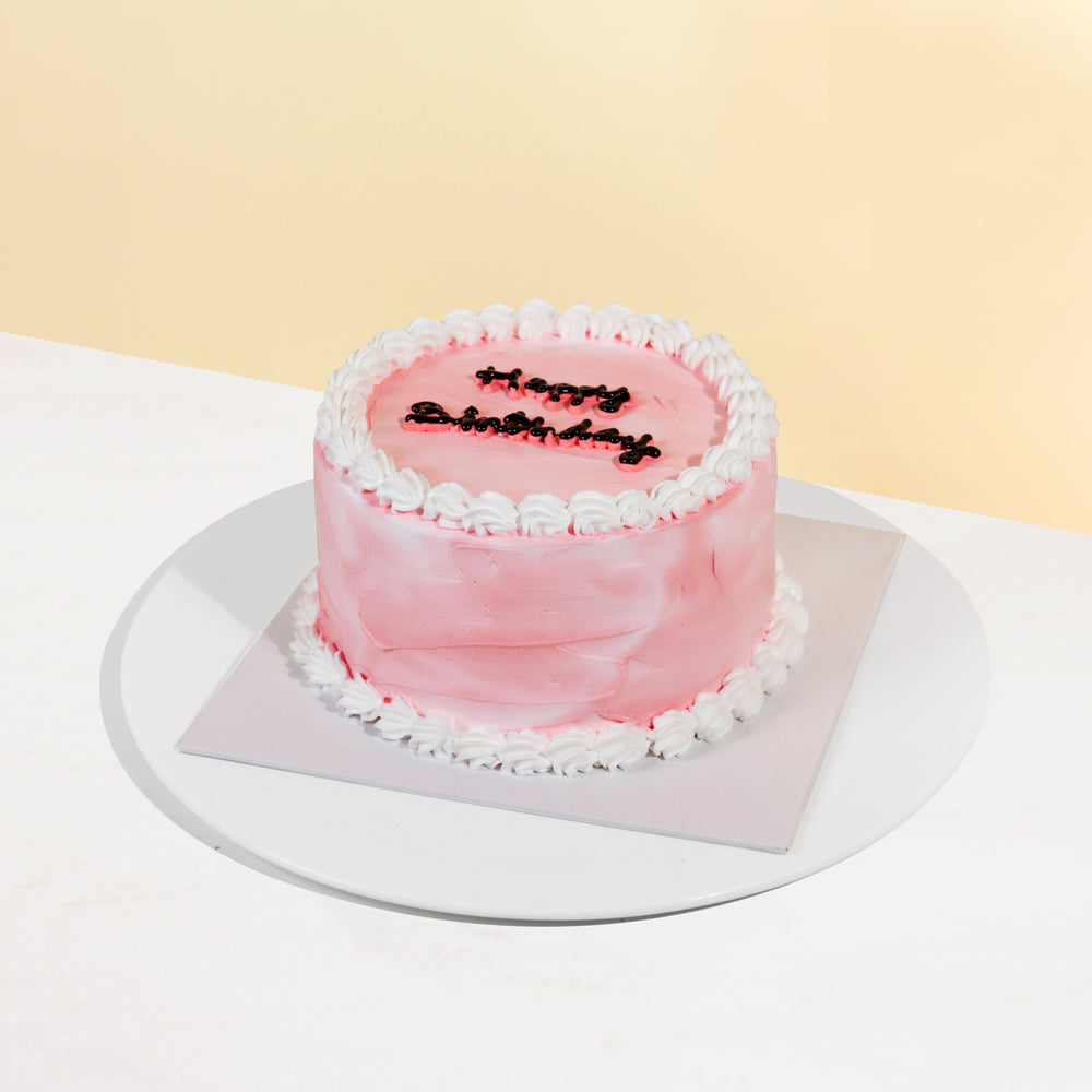 Korean inspired cake with pink buttercream, white hand piped cream and Happy Birthday wordings