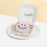 Bento cake with a purple smiley face, and four small flower petals