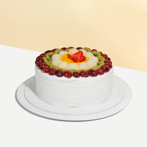 Sponge cake with cream cheese frosting, layered and topped with fresh fruits