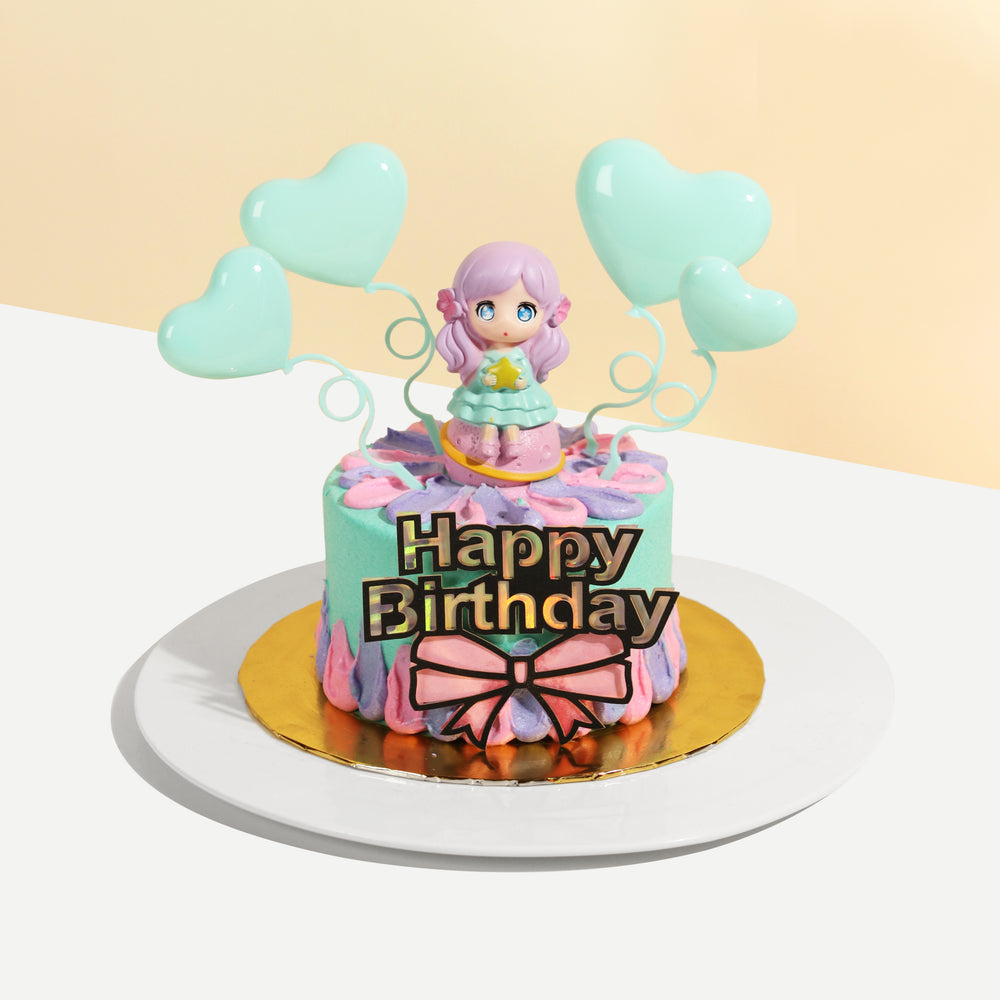 Teal buttercream cake with blue and pink accents, with a figurine on top
