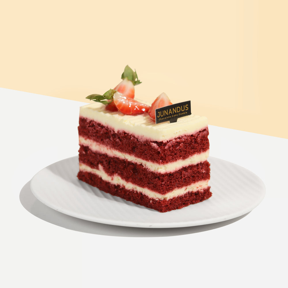 Red velvet cake with 3 layers of cake and cream cheese, topped with strawberries