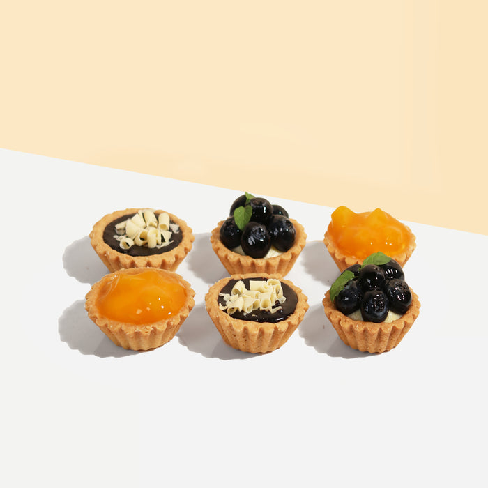 Tarts with blueberry, mango and chocolate toppings