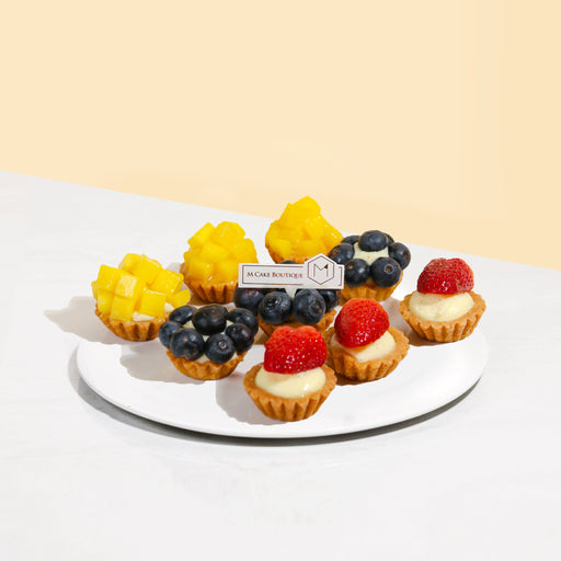 Tarts filled with pastry cream, topped with mangoes, blueberries and strawberries