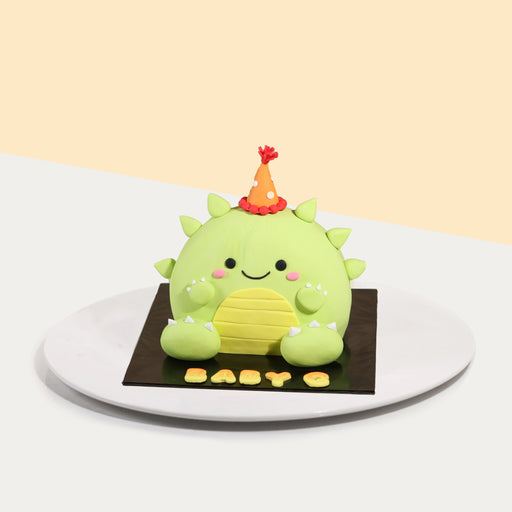 Cute dinosaur shaped cake, wearing a mini party hat