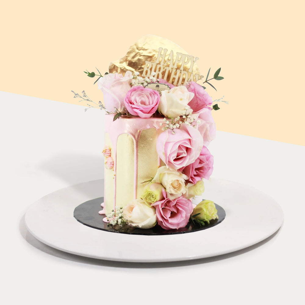 Yellow buttercream cake with pink drizzle, designed with fresh roses