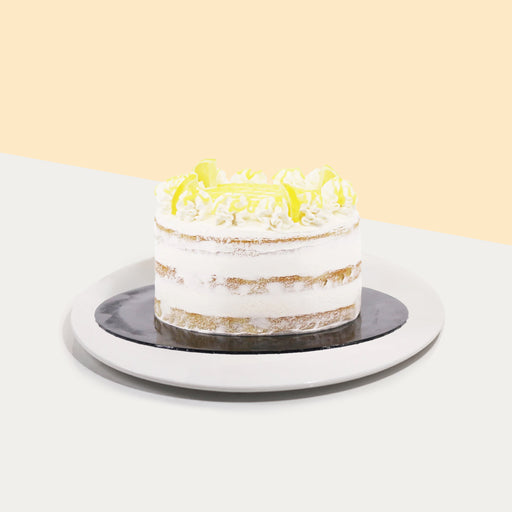 Zesty lemon cake with freshly whipped cream, topped with lemon curd and candied lemons