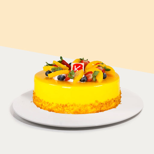 Yellow cake with mango fruit filling, topped with more mangoes, strawberries and blueberries.