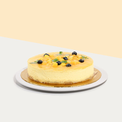 Baked cheesecake with mango puree, topped with mango pieces and blueberries