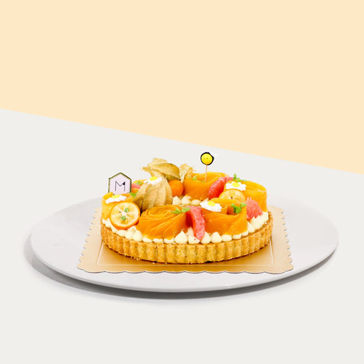 Buttery tart filled with almond frangipane and pastry cream, topped with mango roses, grapefruits and gooseberries
