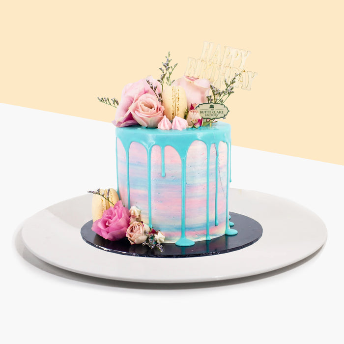 Buttercake with ombre design, along with blue chocolate drip, topped with fresh roses