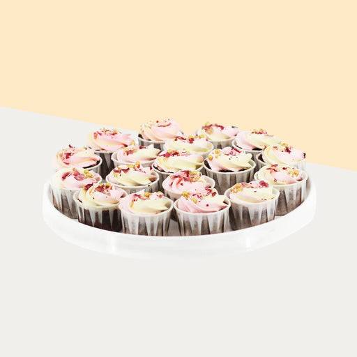 Mini cupcakes with yellow and pink buttercream, topped with edible pearls and rose petals