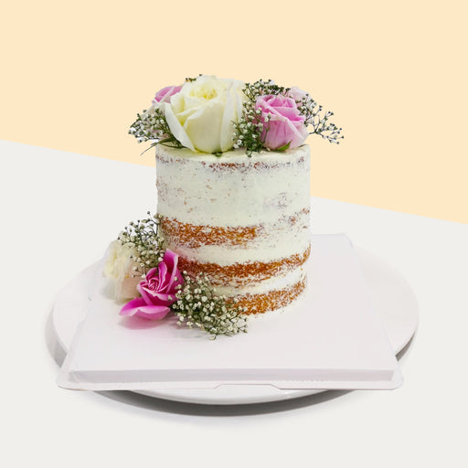 Butter vanilla semi naked cake, topped with fresh roses and baby breath