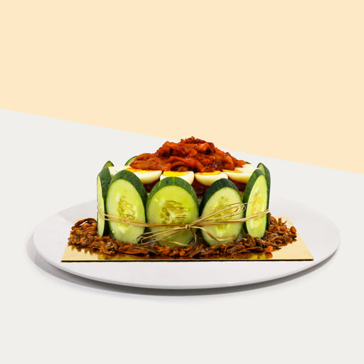 Nasi lemak cake with peanuts, anchovies, cucumber slices, boiled eggs and sambal sotong