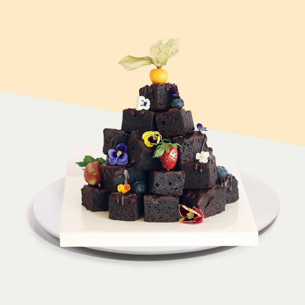 Brownie tower consisting of 25 pieces of brownie bites, strawberries, gooseberries and edible flowers