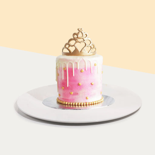 Pink buttercream princess cake with a golden crown